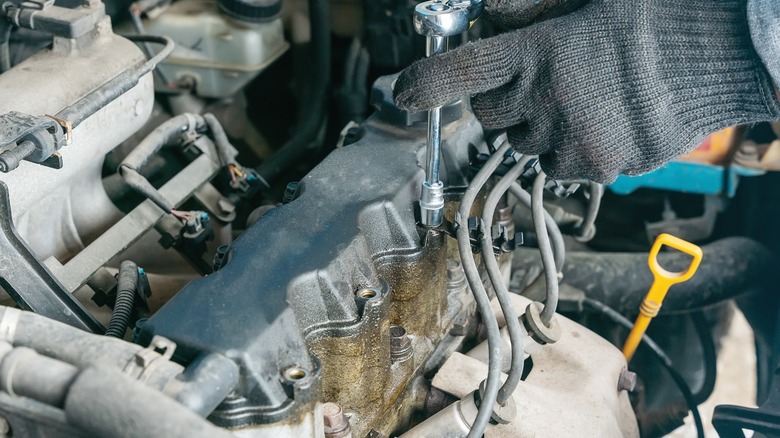 Visible oil leaks on the valve cover of a car engine
