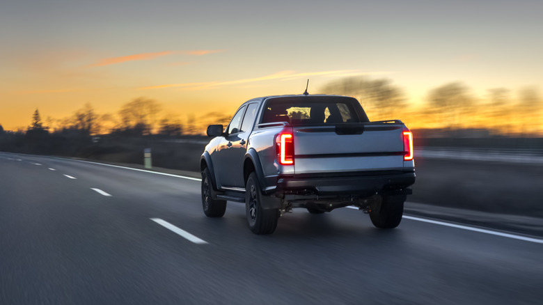 A pickup truck on the highway at sunset