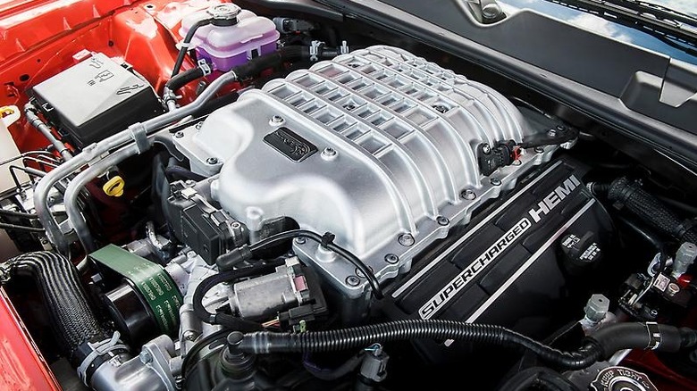 A close up of the Hellcrate Redeye supercharged V8 in the engine bay of a red car.