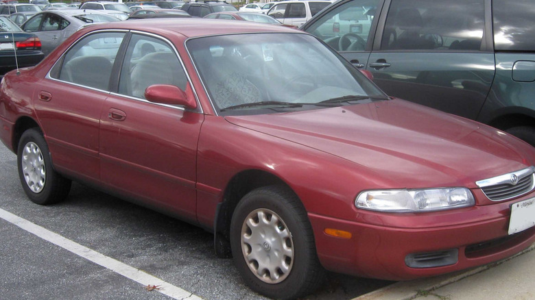 Red 1997 Mazda 626 parked in a parking lot.