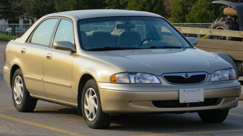 A champagne Mazda 626 in a parking lot.
