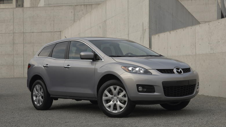 Silver 2007 Mazda CX-7 SUV in brutalist urban environment.