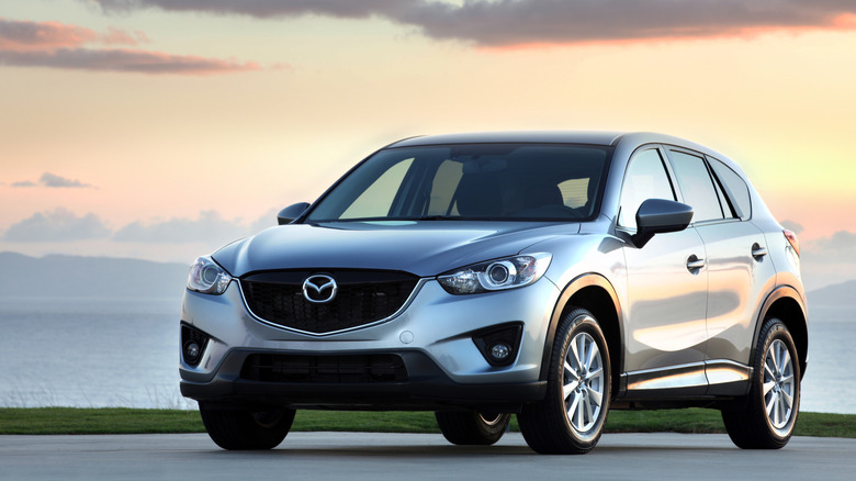 2014 Mazda CX-5 set in front of a waterfront sunset landscape.