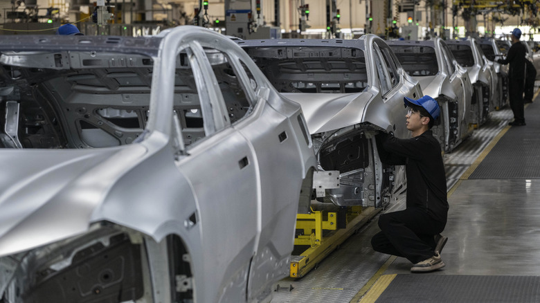 A worker checks the frame of a car on the production line for electric vehicle maker Zeekr at its factory on May 29, 2025 in Ningbo, China.