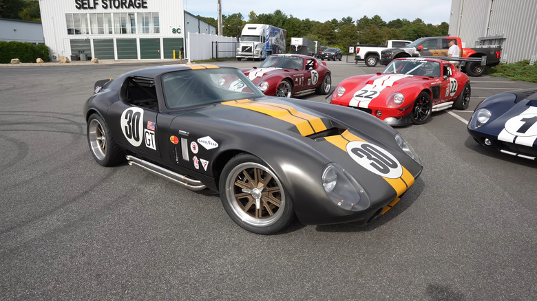 A Factory Five Racing Coupe kit car parked by other cars
