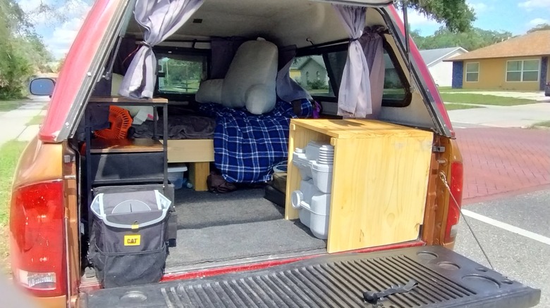 Original image of author's camping setup in the back of his pickup truck with a topper.