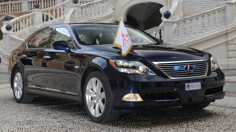 A dark-colored 2011 Lexus LS 600h L parked in front of a large staircase.
