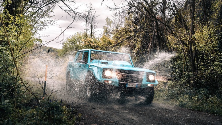 Pale blue Lamborghini LM002 powering through water.