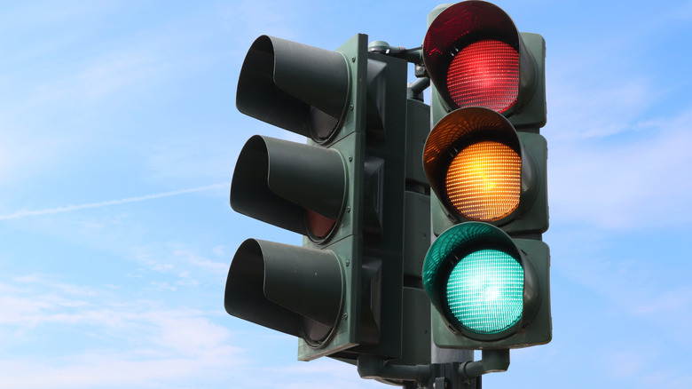 Traffic light isolated in the sky with all the lights on.