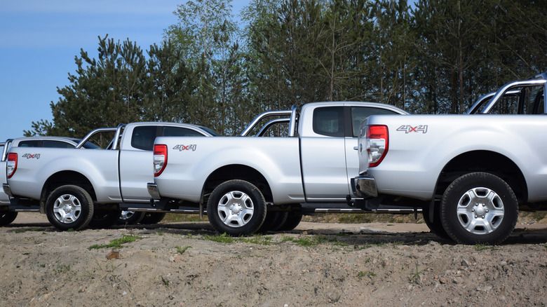 A group of Ford Ranger midsize trucks parked on a dirt road