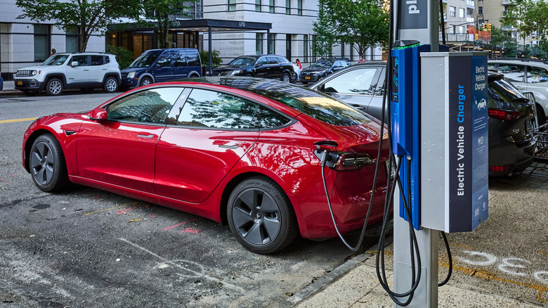 A Tesla Model 3 parked and using a public charger in New York City.