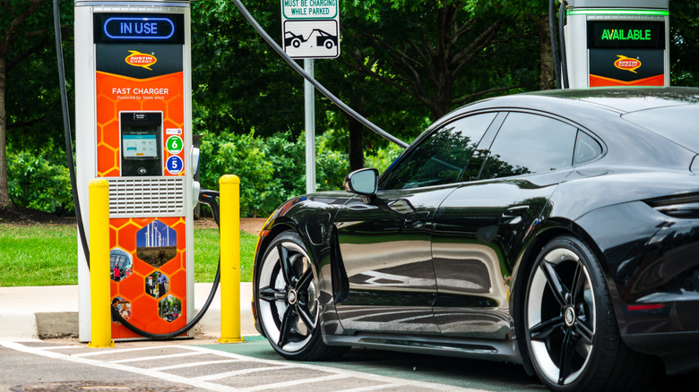 A car parked at a DC fast charging station outside.