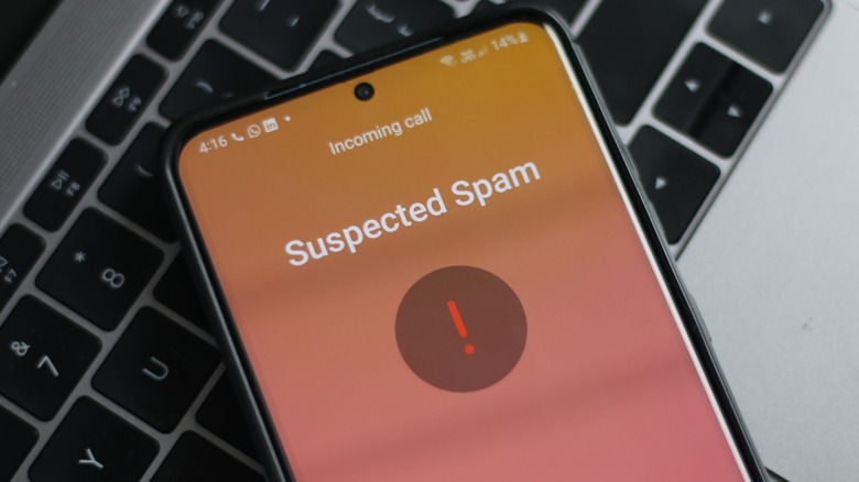 A smartphone with "Suspected Spam" on the screen