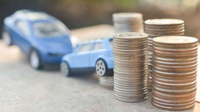 Toy cars next to stacks of coins