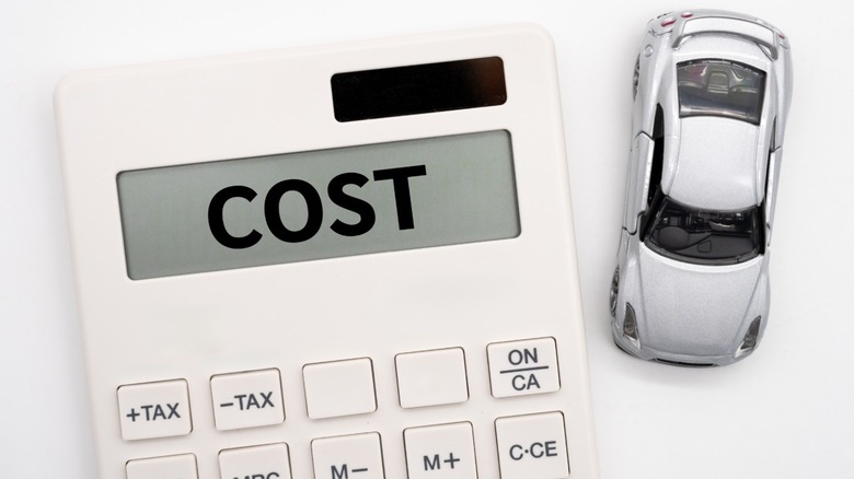 A toy car next to a calculator whose screen says, "COST"