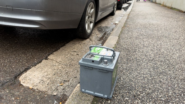 A discarded car battery left on a curb