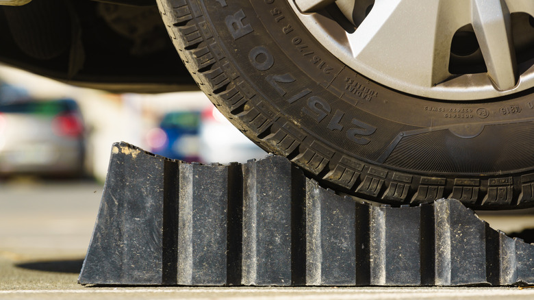 A close-up of a wheel and tire atop a plastic ramp