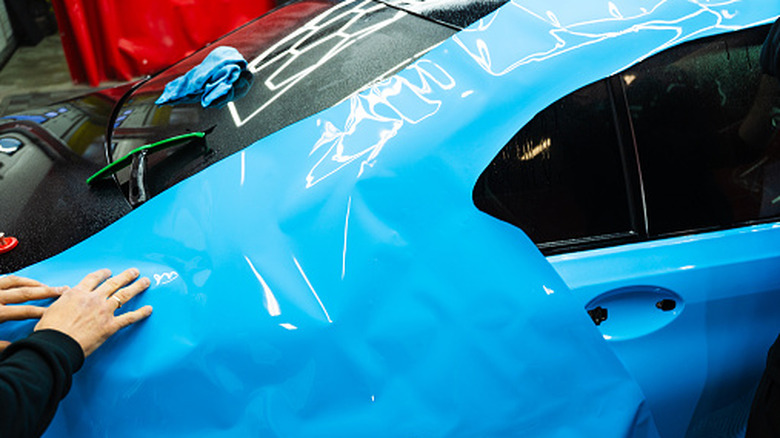 Paint protection film (PPF) being applied to car in a garage