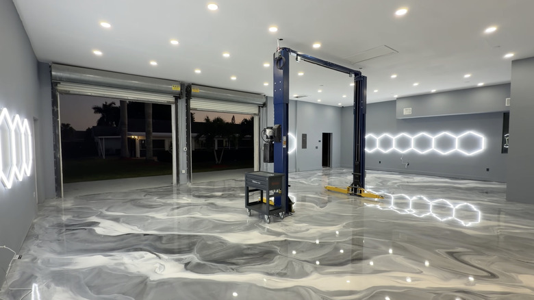A high-end car workshop garage featuring octagonal lights and a swirled epoxy floor coating.
