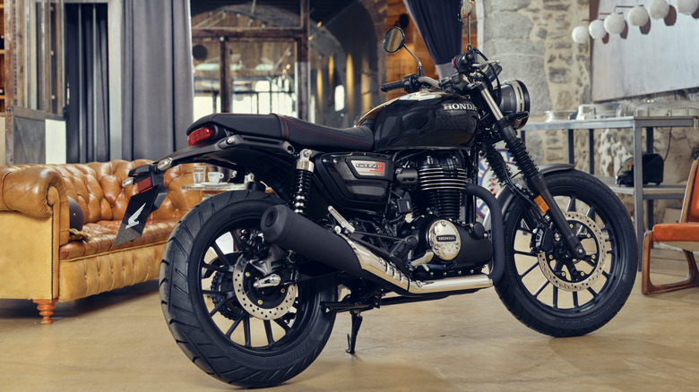 A black air-cooled Honda motorcycle lounging indoors.