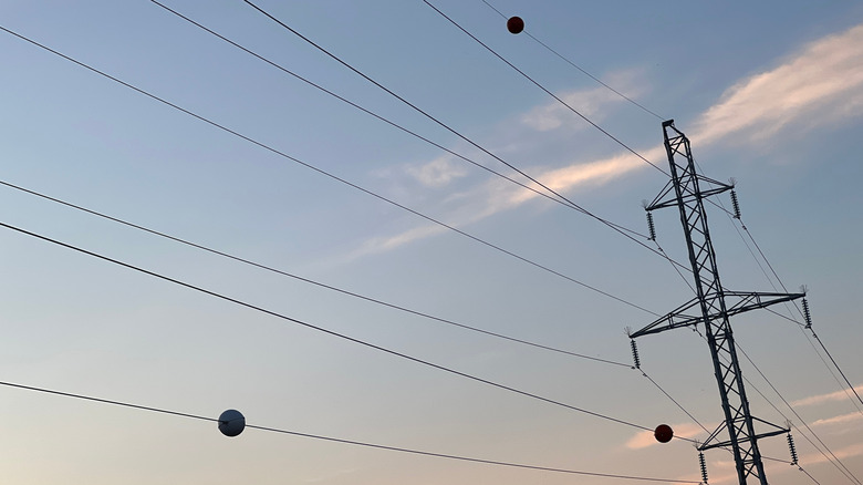 Three aviation marker balls on power lines and telecommunication cables between towers