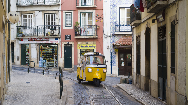 A Piaggio Ape navigating a narrow cobbled street