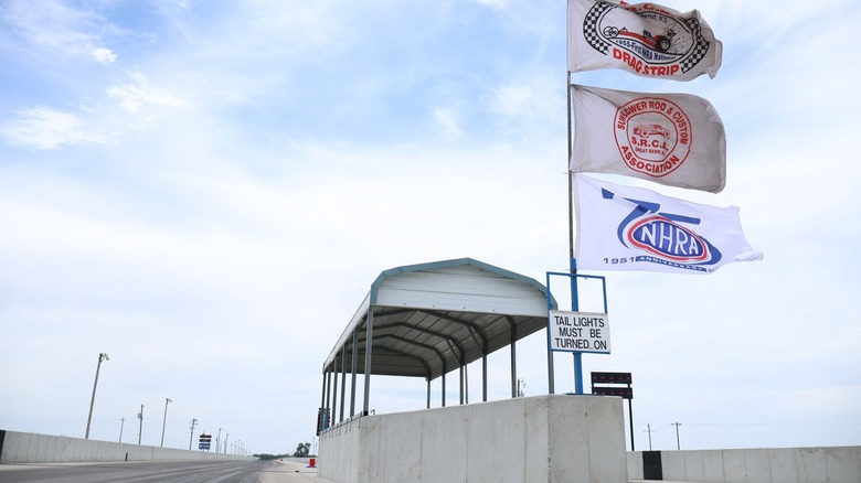 Two SRCA racing flags and a 75 years of NHRA flag wave in the center island of the two lanes at the SRCA Dragstrip of Great Bend.