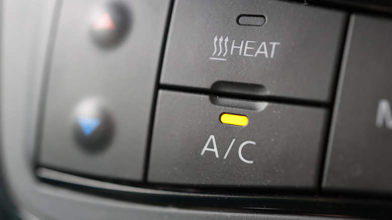 Close-up of a car dashboard AC button turned on