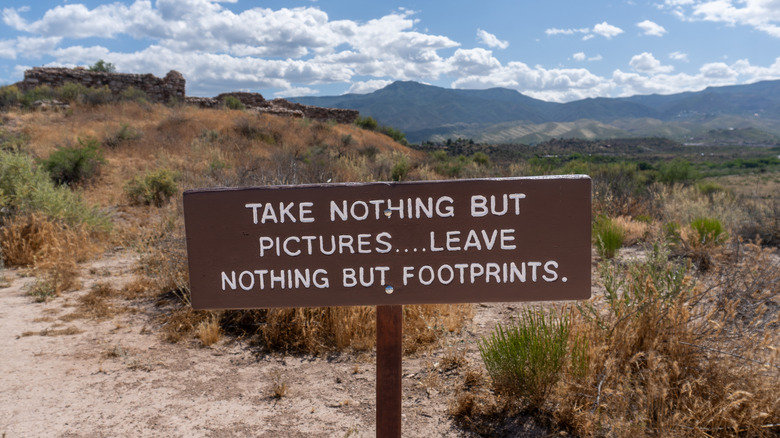 A sign reading "take nothing but pictures. leave nothing but footprints."