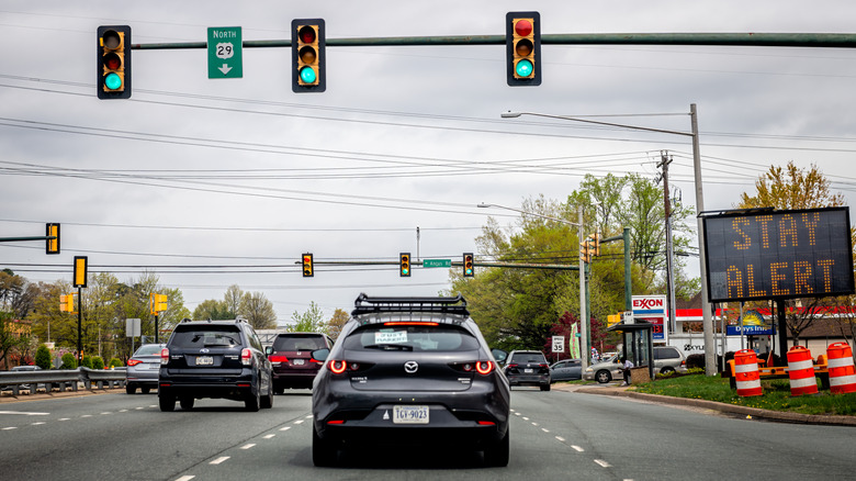 Cars on the road with traffic lights above
