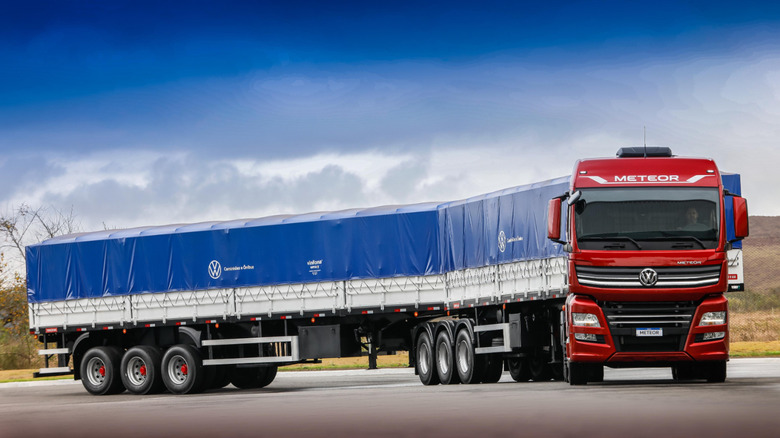 A parked VW Meteor semi truck with a long covered trailer