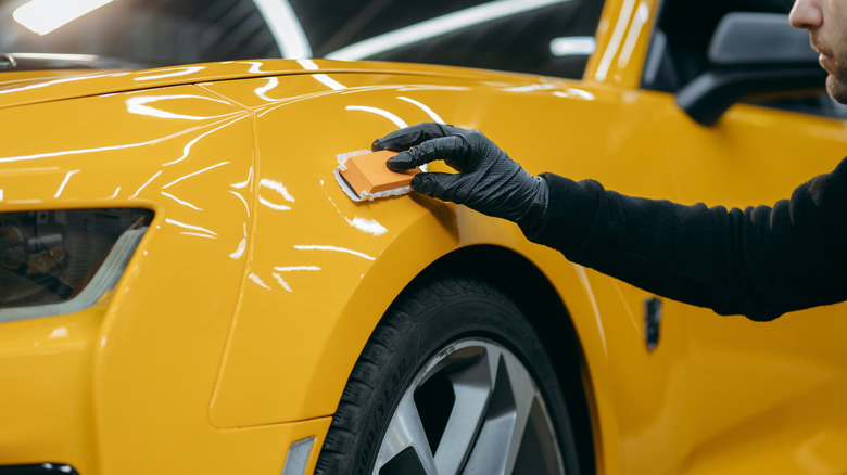 A person detailing a yellow car