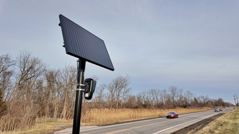 A Flock camera surveils a rural highway as a Chevrolet Cruz passes by
