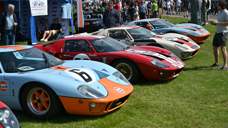 A line of vintage Ford GT40s parked on a lawn on display.