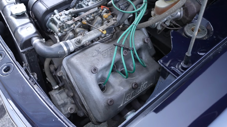 Closeup of a silver valve cover on a Lancia Fulvia's V4 engine