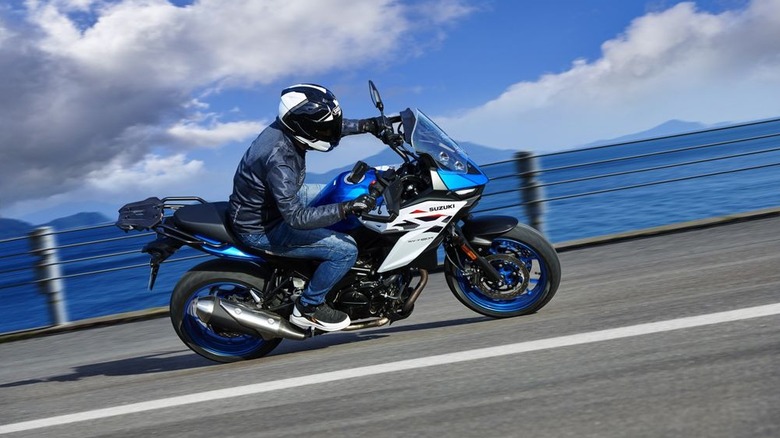 A Suzuki SV-7GX leaning through a turn on a road by the water