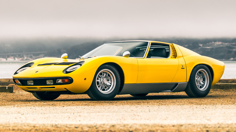 Yellow Lamborghini Miura parked in a scenic location.