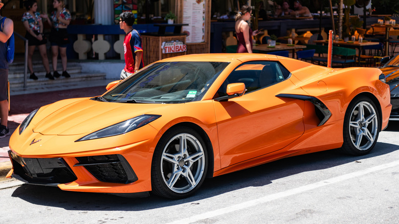Orange C8 Corvette parked outside a shop in Miami.