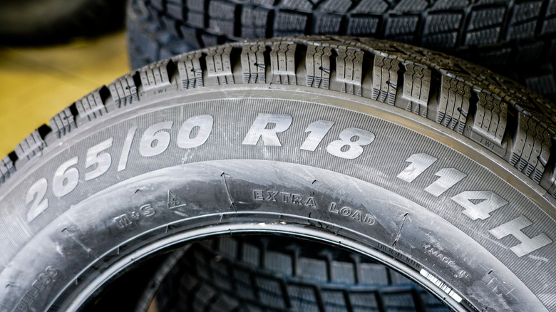 A tire's sidewall with markings for the width, aspect ratio, wheel size, load index, and speed rating