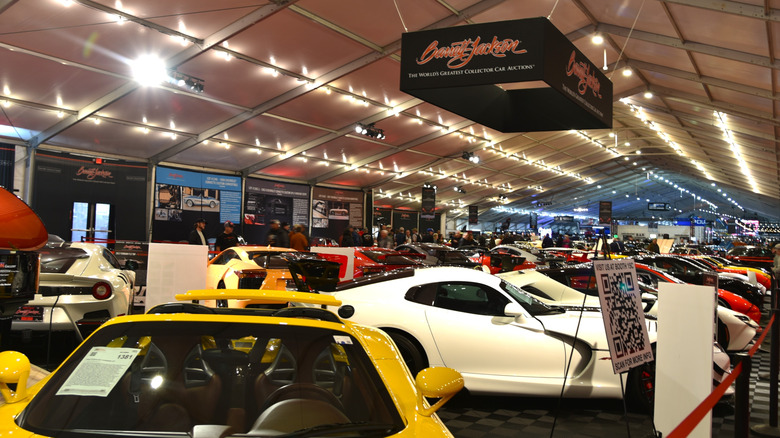 High end cars park under the lights awaiting auction.