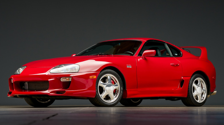 A red Mk4 Supra in a dark room.