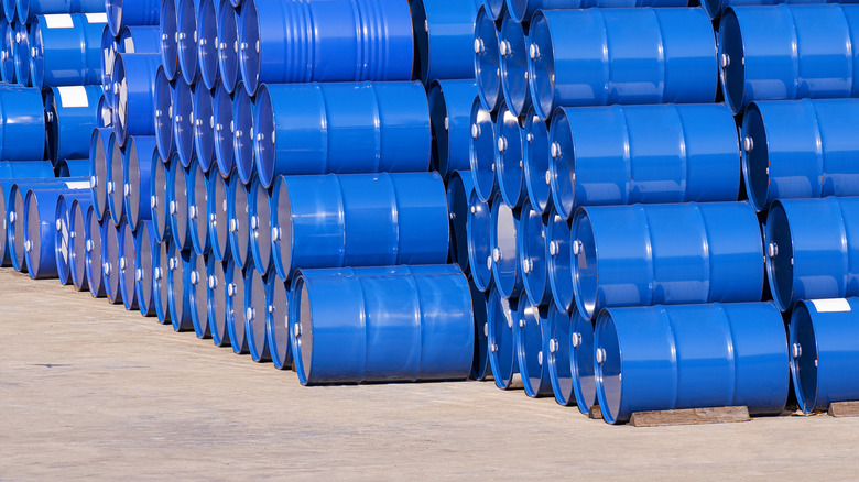 Stacks of blue oil drums on a cement foundation.