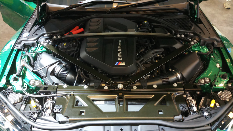 Engine bay of a G80 BMW M3, showing the twin-turbo S58 inline-six