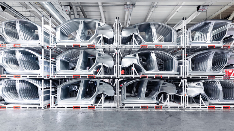 Rows of vehicle parts are stacked in a factory.