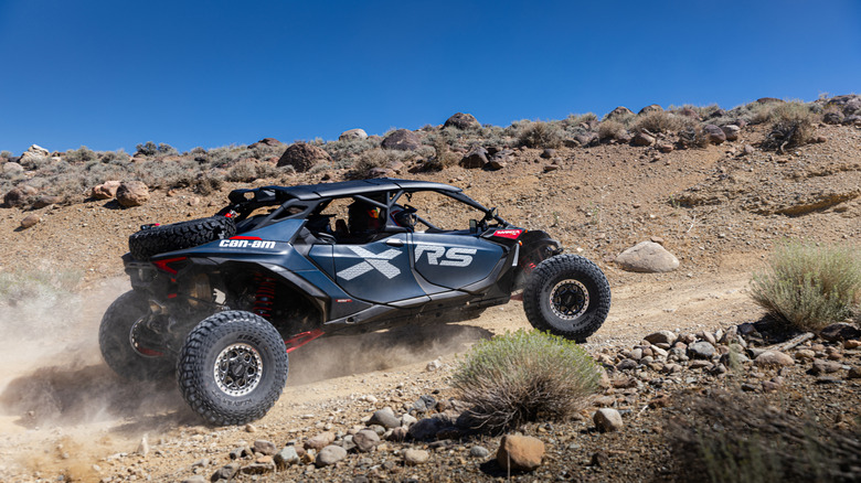A 2026 Can-Am Maverick R MAX climbing a slight rise on the Vegas to Reno course