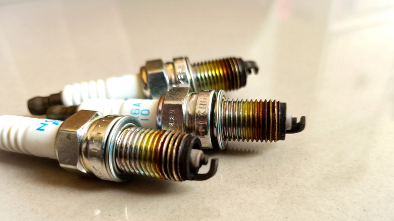 Three used NGK spark plugs grouped together