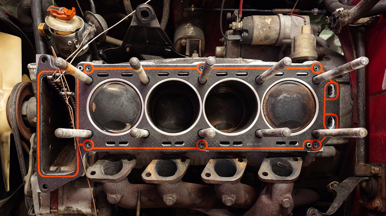 An four-cylinder engine with the cylinder head removed, showing two pistons at top-dead center.