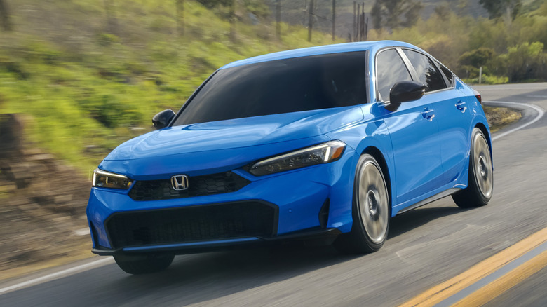 The front 3/4 of 2026 Honda Civic Hatchback driving on a country road