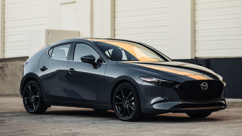 The front 3/4 of 2026 Mazda3 hatchback parked outside a loading dock