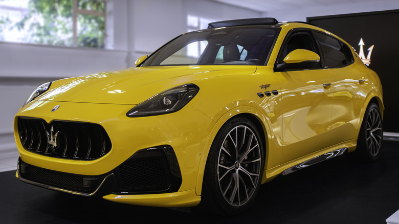 A yellow Maserati Grecale parked in a room.